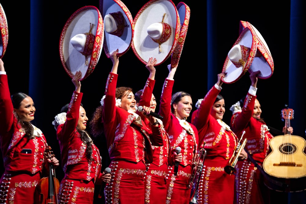 Mariachi Bonitas de Dinorah members raising their hats