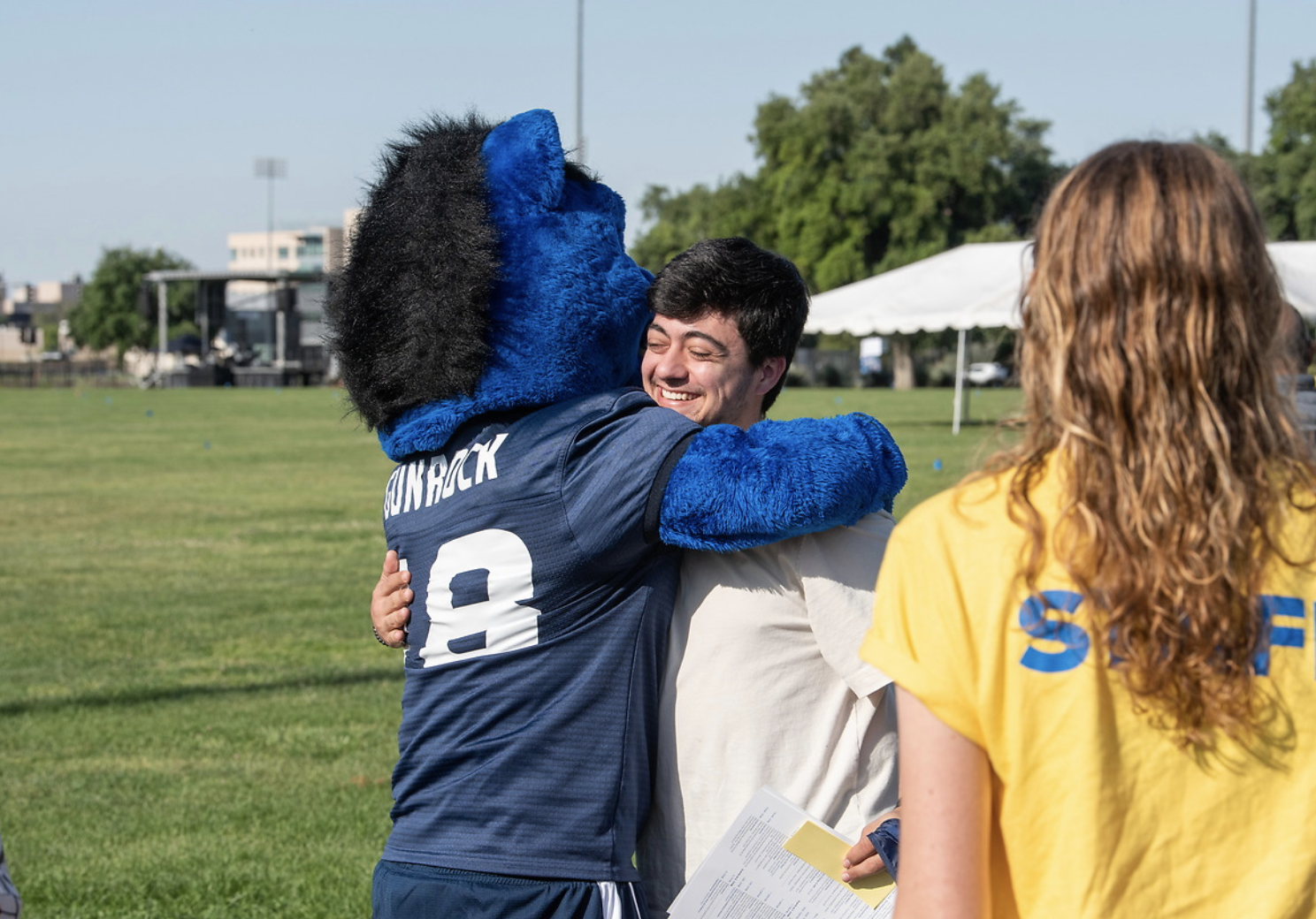 Gunrock giving a student a hug.