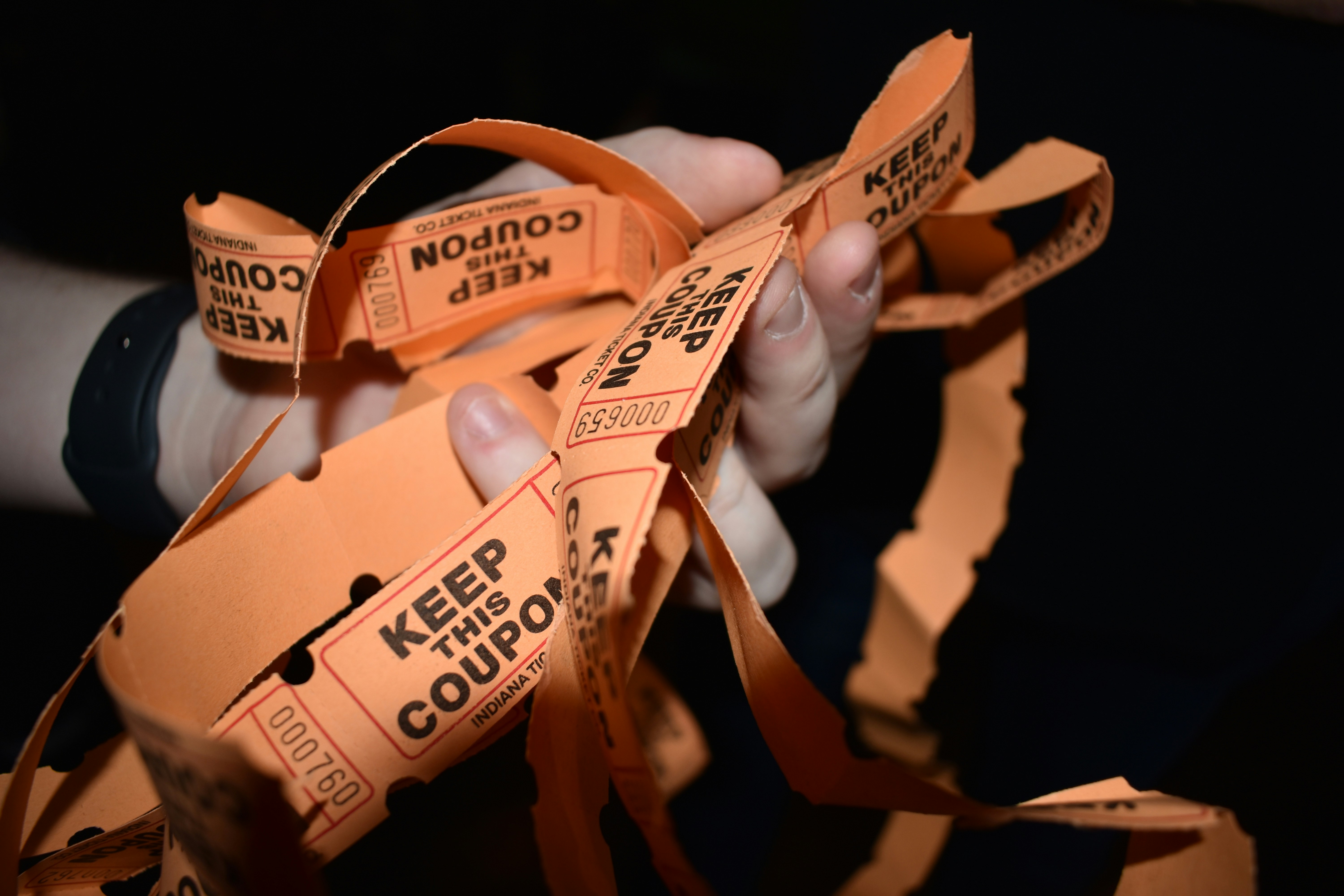 Hand holding a bunch of raffle tickets