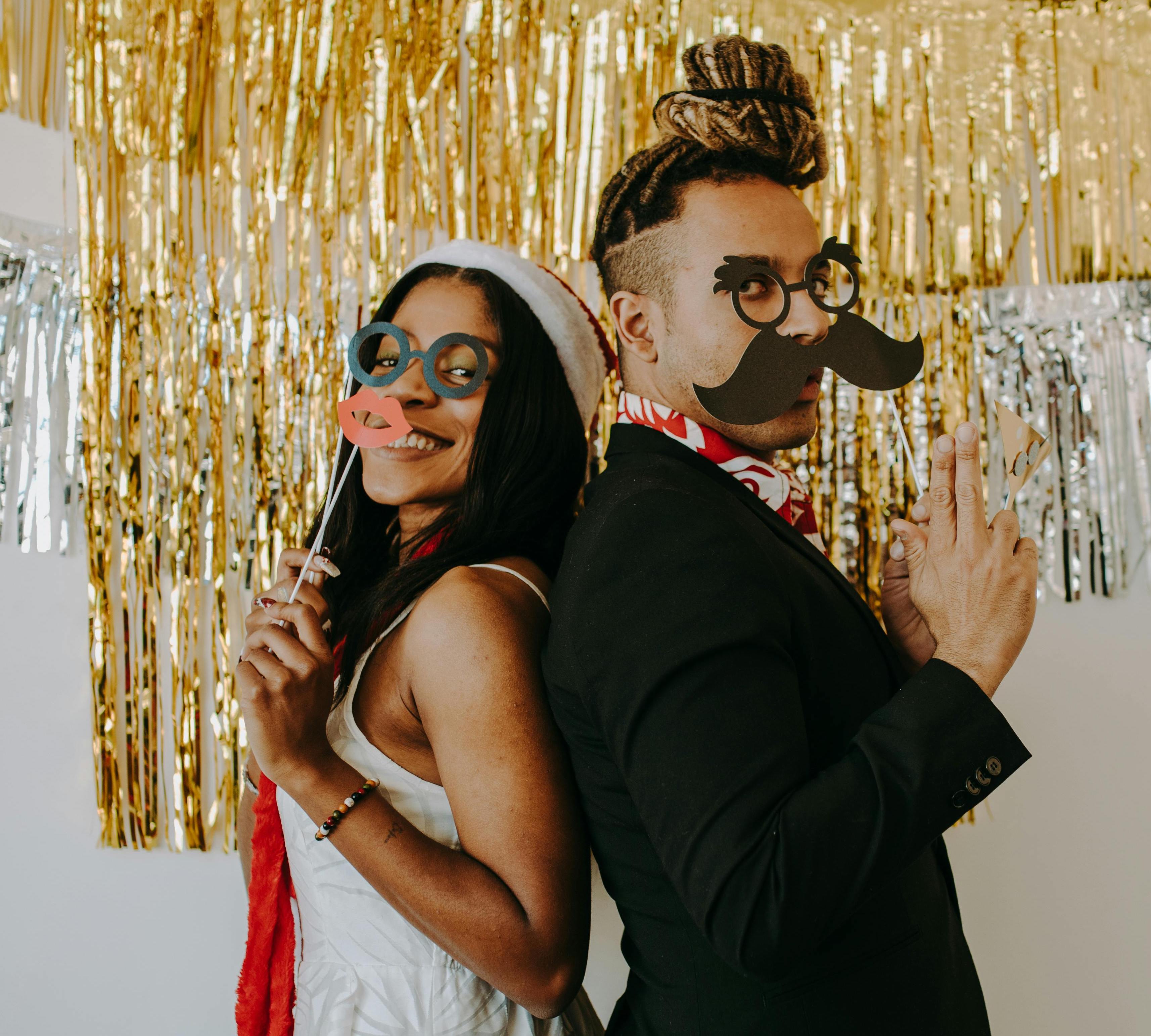 Two people smiling with props in hand.