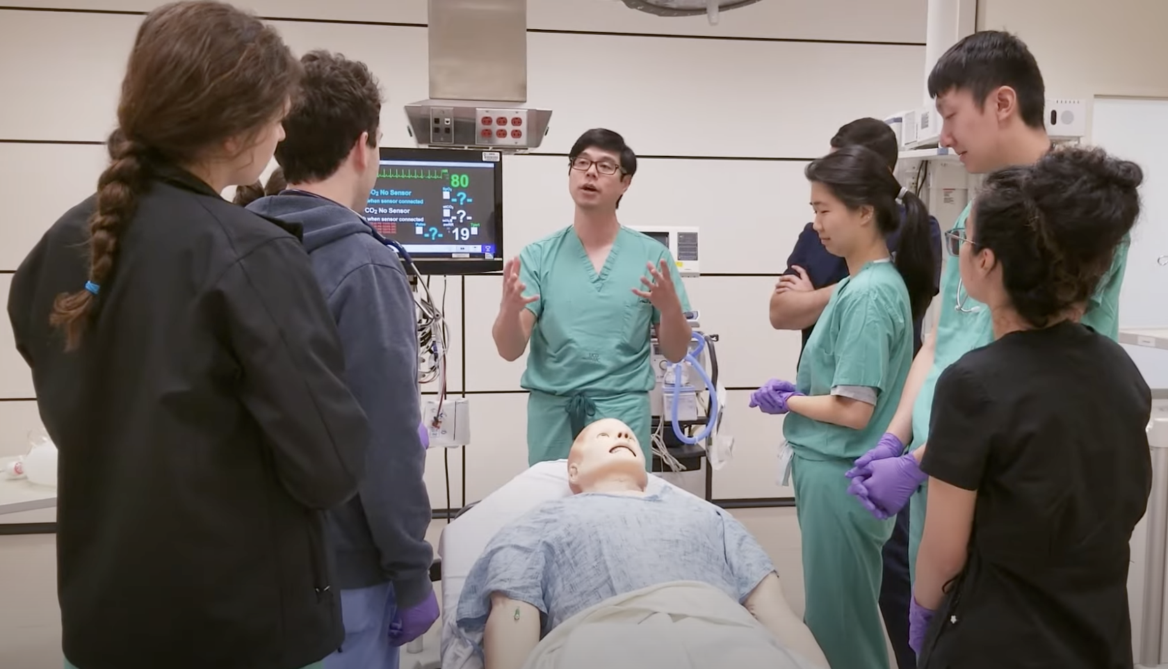 Medical professional speaking in front of students in the UCDH Simulation Center.