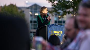 UC Tech managing sponsor, Iris Chelaru, speaking on a UC Davis Health podium.