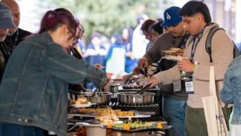 Attendees reaching for food at the UC Davis Health evening reception