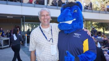 Attendees smiling with the UC Davis blue horse mascot, Gunrock
