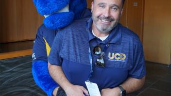 Attendees smiling with the UC Davis blue horse mascot, Gunrock