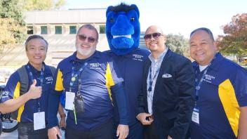 UC Tech volunteers smiling with the UC Davis blue horse mascot, Gunrock