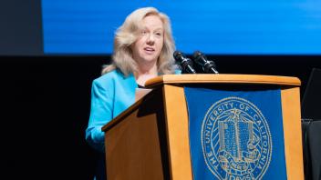 UC Davis Provost, Mary Croughan, speaking on the podium.