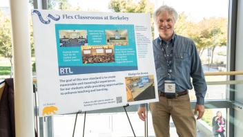 UC Tech poster presenter smiling with their poster presentation