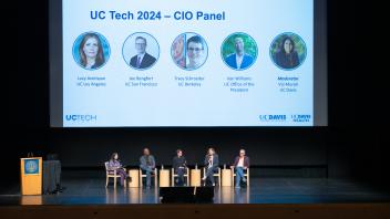 CIO panel sitting in a row with a presentation slide in the background.