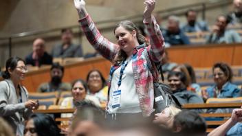 Vendor raffle winner raising hands in celebration.