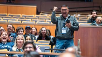 Vendor raffle winner raising hands in celebration.