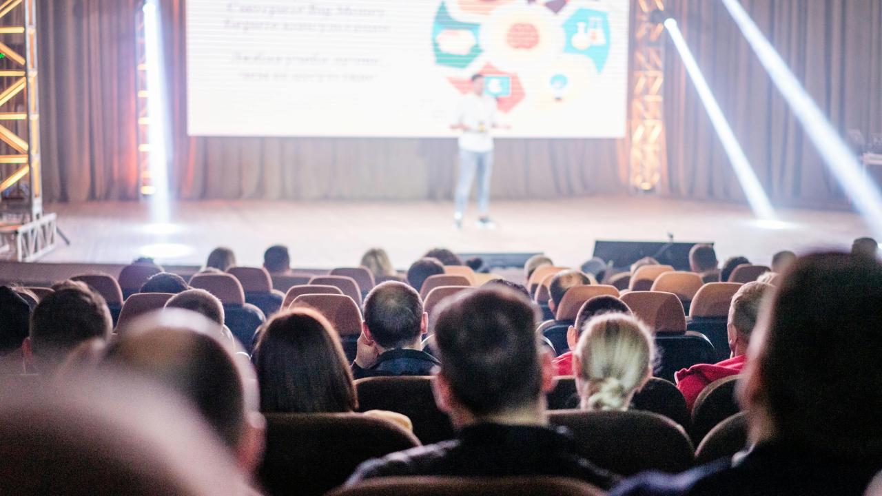 Photo of a presentation with heads in the back.