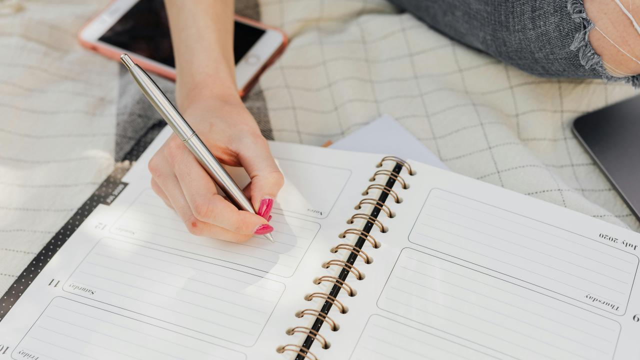 Person writing in a planner