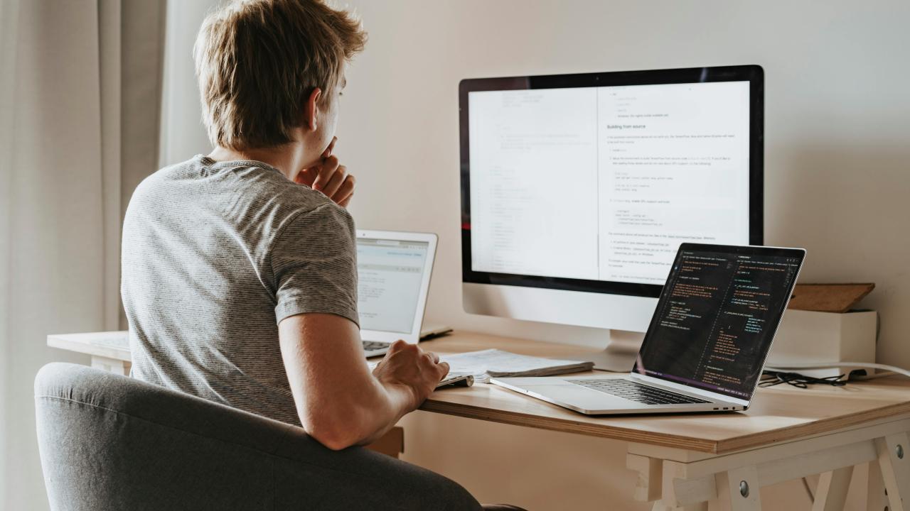 Man sitting in chair looking at his laptop