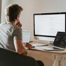 Man sitting in chair looking at his laptop